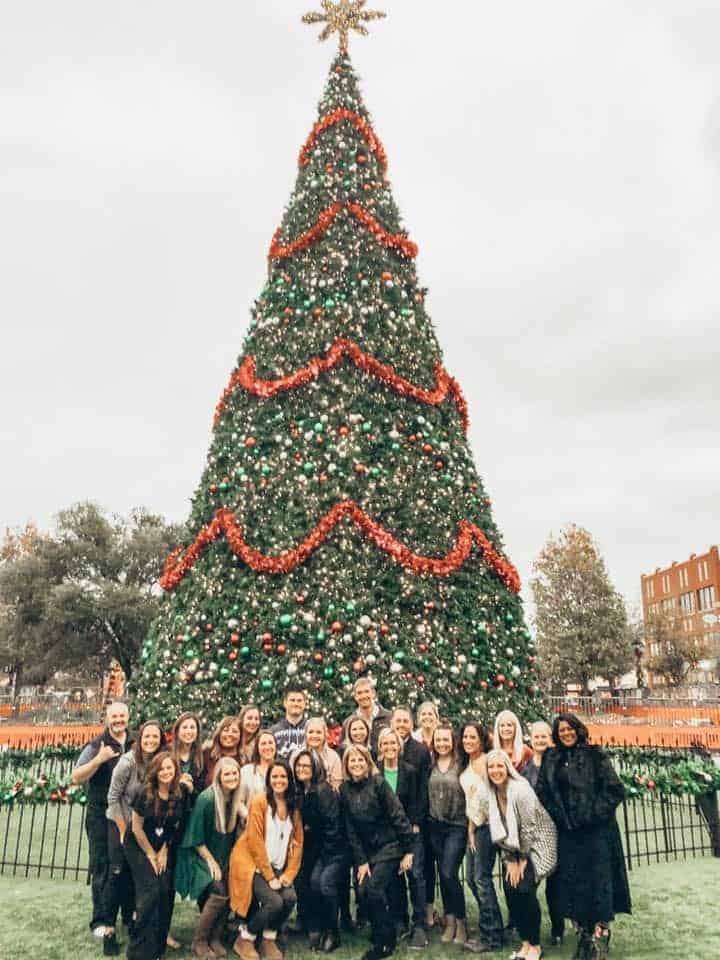carrie munzy and the whole Team under a huge Christmas tree