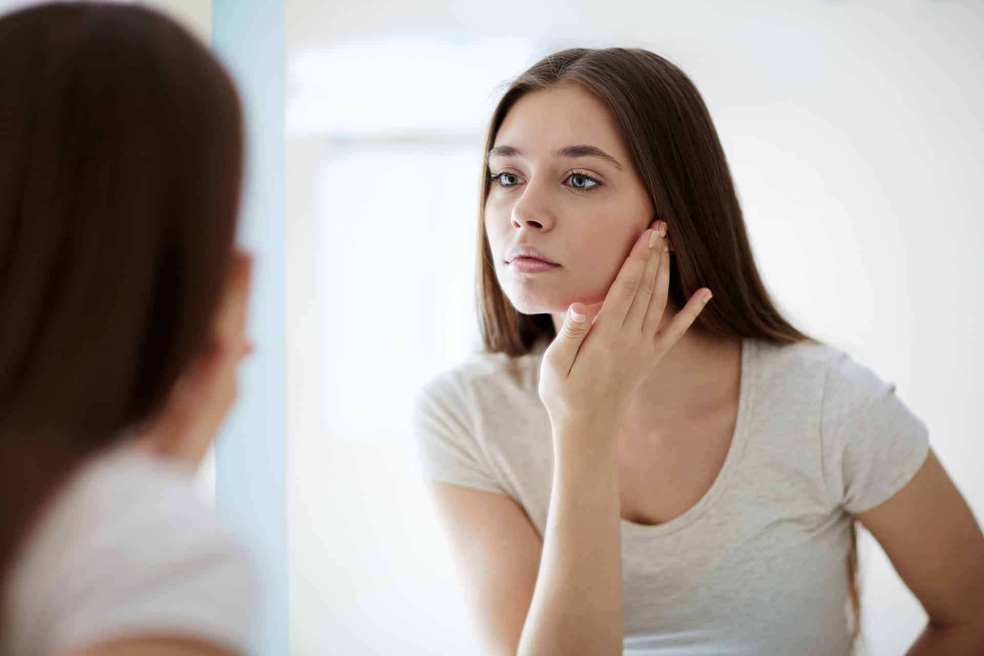 woman checking on Missing Tooth in the mirror
