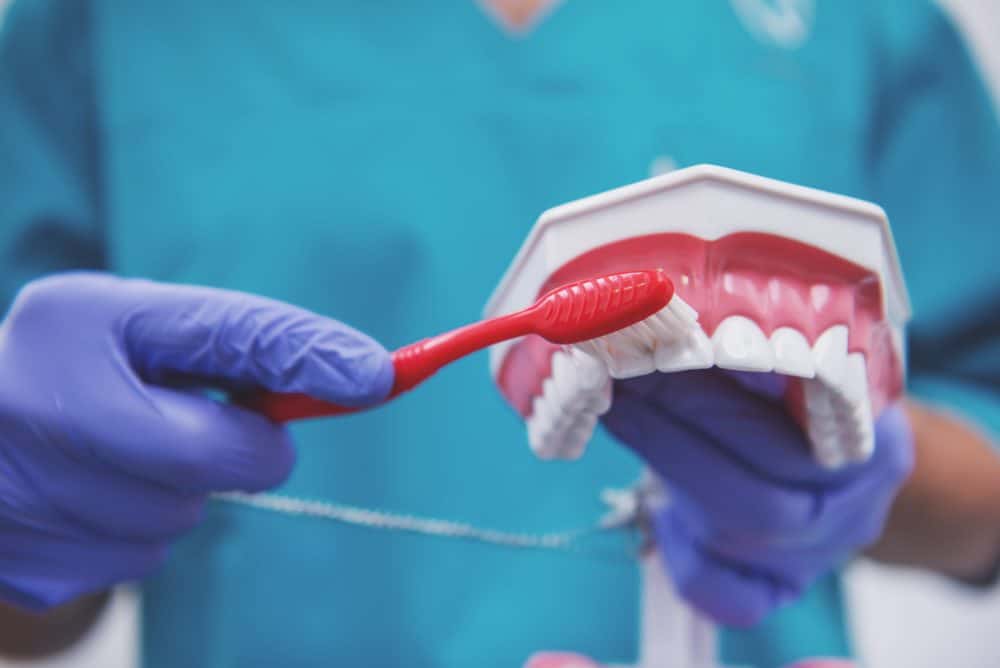 dentist showing how to avoid dental hygiene mistakes