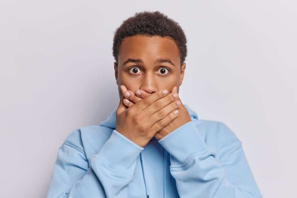 man covering his mouth because his veneers fall off