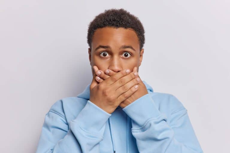 man covering his mouth because his veneers fall off