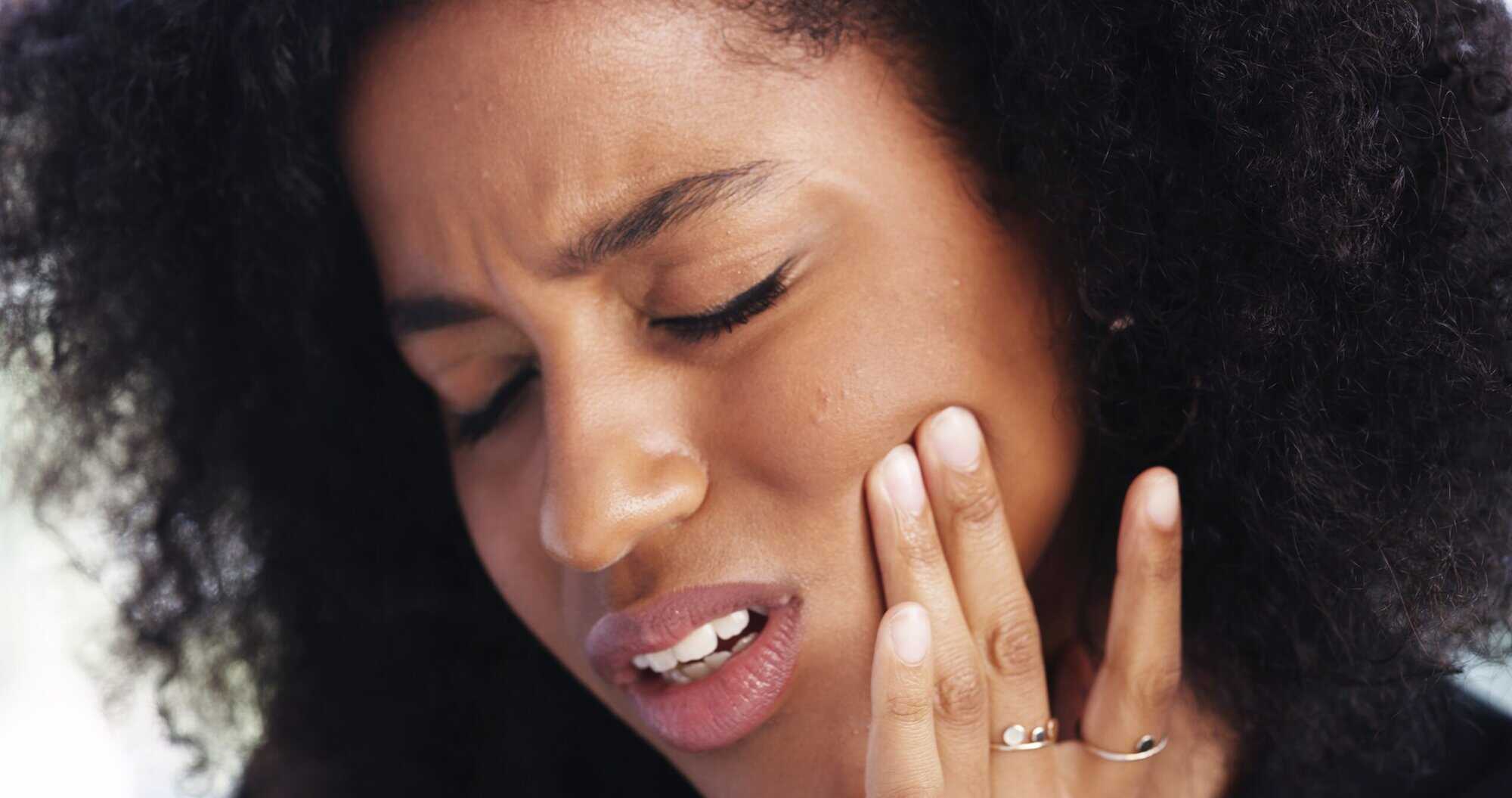 Toothache,,Sad,And,Face,Of,African,Woman,At,Home,For closeup of a woman suffering from tooth pain, need for a root canal