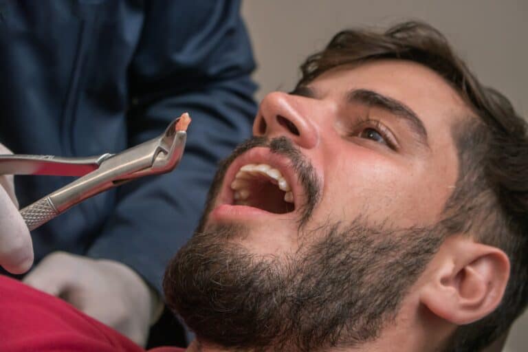 young man with a bear having a tooth pulled
